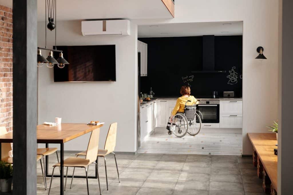 A modern kitchen designed for accessibility, featuring a person in a wheelchair.