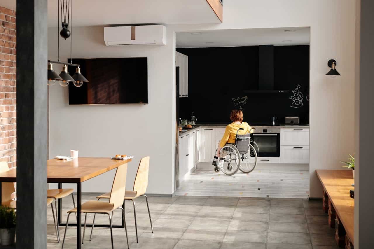 A modern kitchen designed for accessibility, featuring a person in a wheelchair.